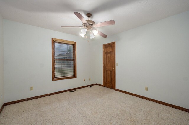 empty room featuring baseboards, ceiling fan, and visible vents