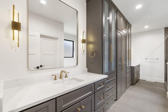 bathroom featuring vanity, recessed lighting, baseboards, and visible vents