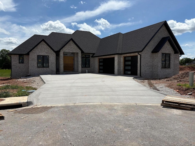 2025 N Unbridled Ct, Springfield, MO 65802 - french provincial home featuring a garage, a shingled roof, concrete driveway, and brick siding