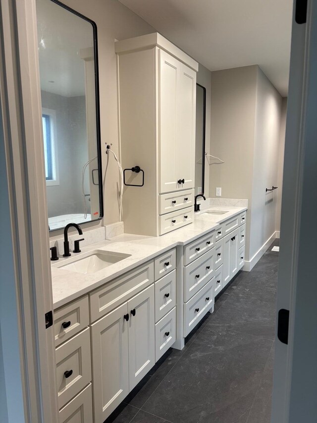 full bath featuring double vanity, a sink, and tile patterned flooring