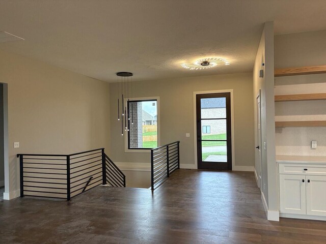entryway featuring baseboards and dark wood-style floors