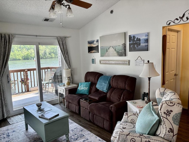 living area with visible vents, lofted ceiling, wood finished floors, a textured ceiling, and a ceiling fan