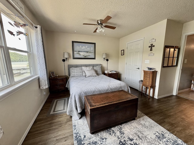 bedroom featuring baseboards, a textured ceiling, ceiling fan, and wood finished floors