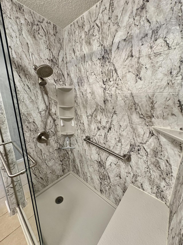 full bathroom with a textured ceiling and a shower stall