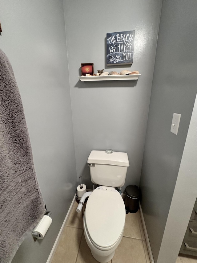 bathroom featuring toilet, tile patterned floors, and baseboards