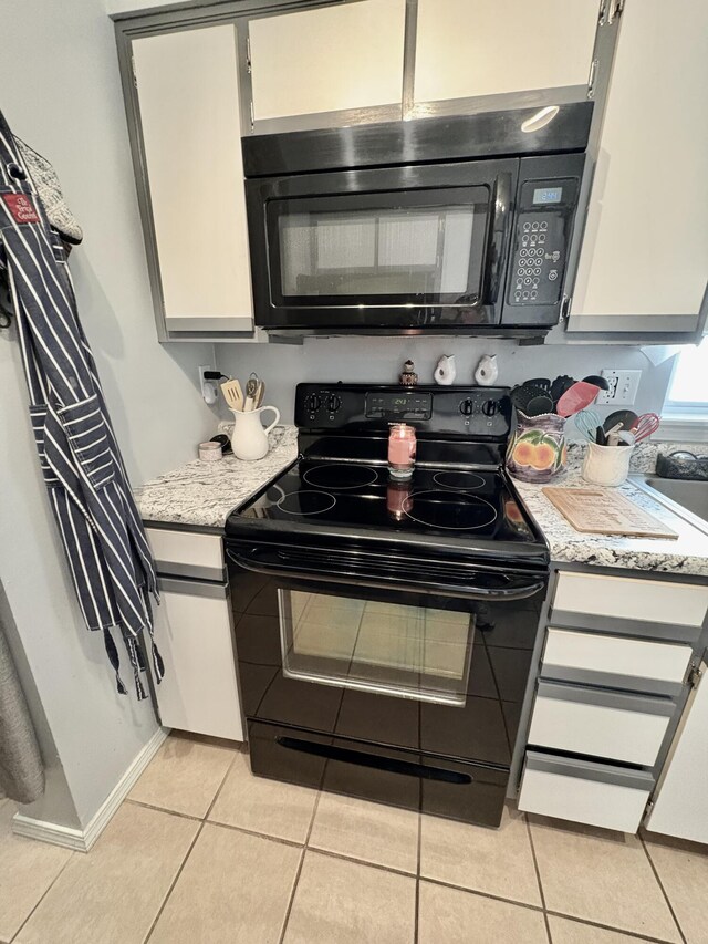 2529 State Highway 176 Unit A9, Rockaway Beach, MO 65740 - kitchen featuring light stone countertops, light tile patterned floors, and black appliances