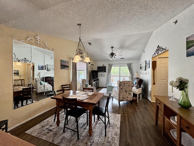 dining room with wood finished floors, lofted ceiling, baseboards, a textured ceiling, and a ceiling fan