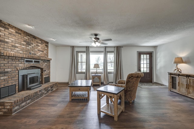 living area with a ceiling fan, a textured ceiling, visible vents, and dark wood finished floors