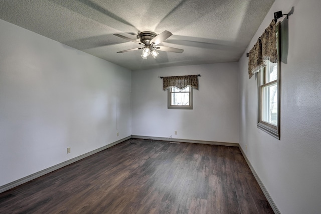 unfurnished room with baseboards, a ceiling fan, a textured ceiling, and dark wood-type flooring