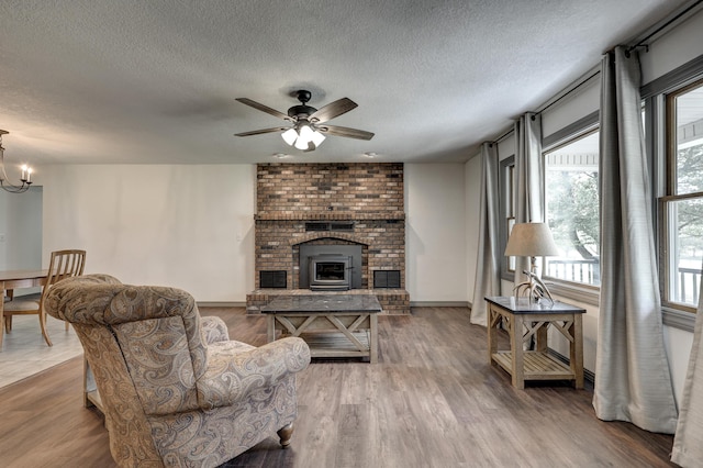 living room featuring a textured ceiling, wood finished floors, and a fireplace