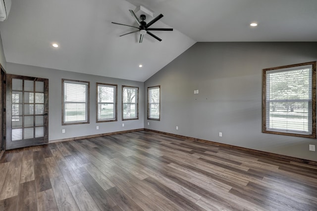 spare room featuring wood finished floors, lofted ceiling, baseboards, ceiling fan, and recessed lighting