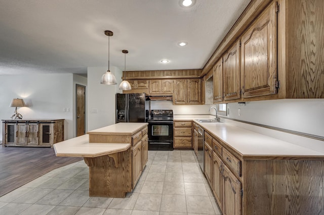kitchen featuring a center island, a sink, light countertops, black appliances, and under cabinet range hood
