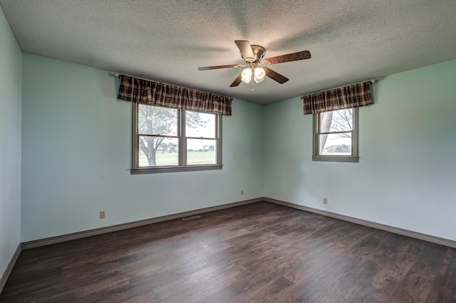 unfurnished room featuring a ceiling fan, dark wood finished floors, and a healthy amount of sunlight