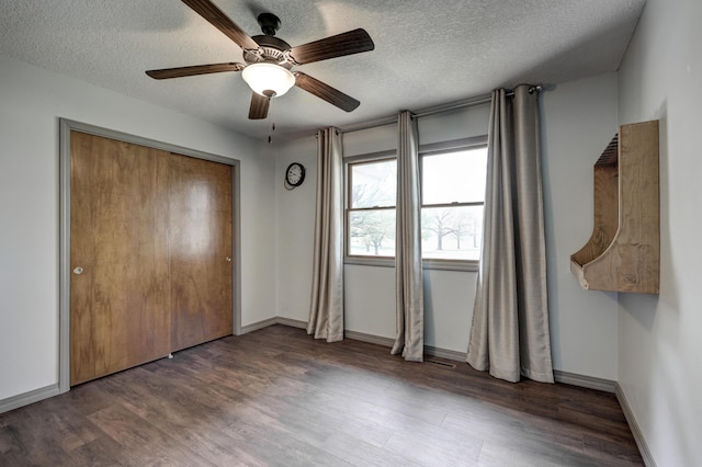 unfurnished bedroom with a closet, wood finished floors, baseboards, ceiling fan, and a textured ceiling
