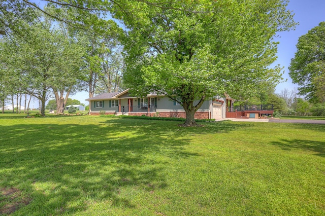 view of yard featuring covered porch, driveway, and a garage