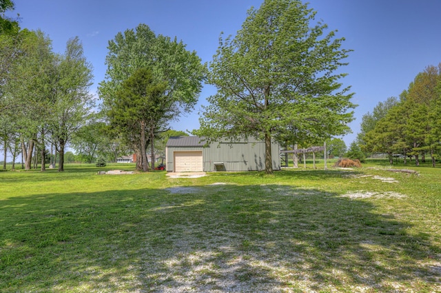 view of yard featuring a garage, an outbuilding, and a pole building