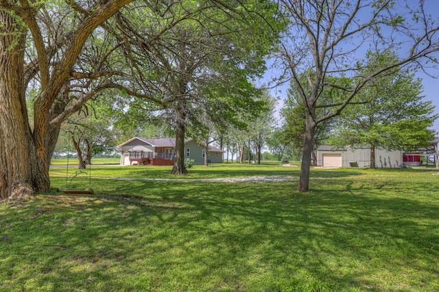 view of yard featuring a garage and a wooden deck