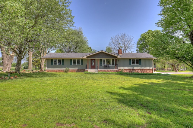 ranch-style home with covered porch, a chimney, a shingled roof, and a front yard