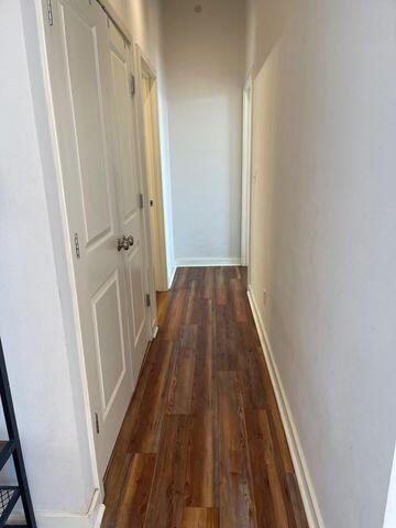hallway with baseboards and wood finished floors
