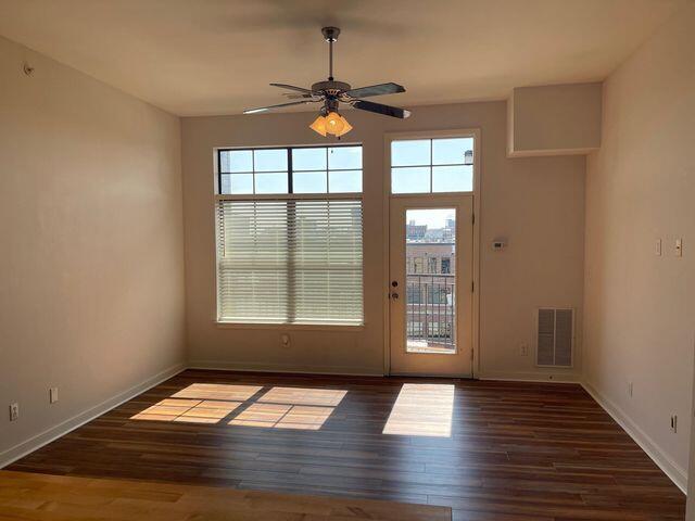 doorway featuring baseboards, ceiling fan, visible vents, and a wealth of natural light