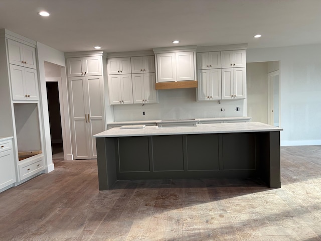 kitchen with a kitchen island, recessed lighting, baseboards, and wood finished floors
