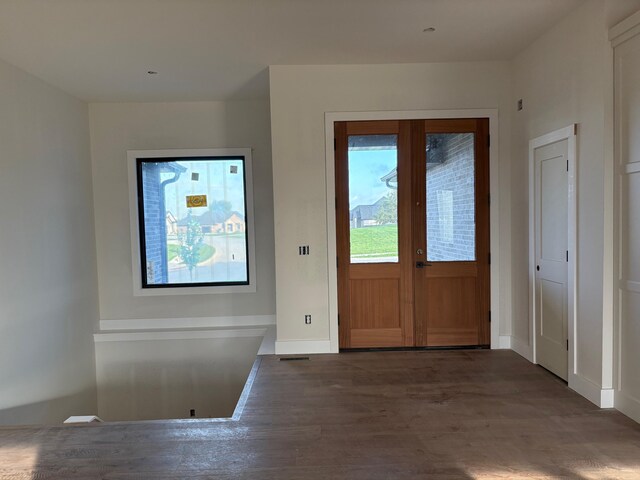 entrance foyer with baseboards, french doors, wood finished floors, and visible vents