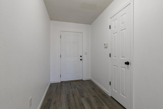 doorway featuring baseboards and dark wood-style flooring