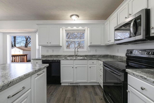 kitchen featuring visible vents, dark wood-style floors, white cabinets, a sink, and black appliances