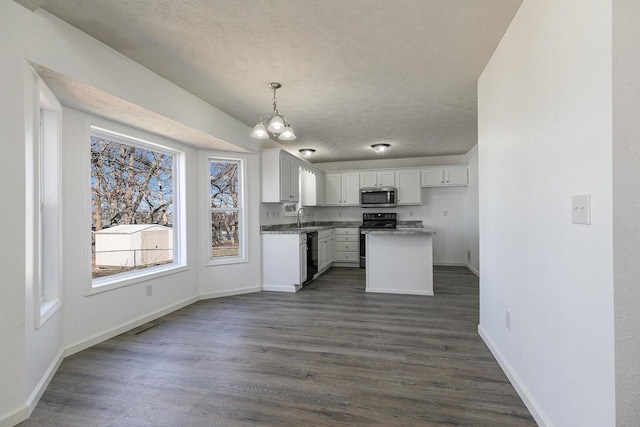 kitchen with appliances with stainless steel finishes, a sink, baseboards, white cabinets, and dark wood-style floors