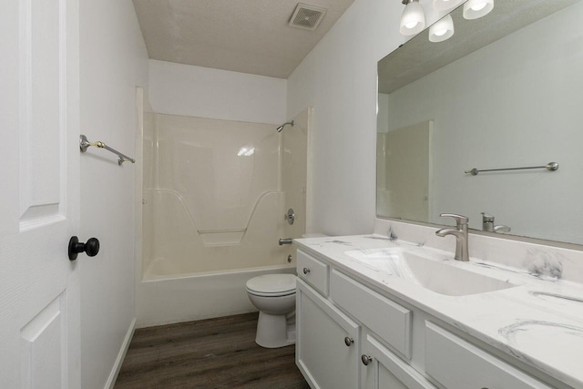 bathroom with washtub / shower combination, vanity, toilet, wood finished floors, and visible vents