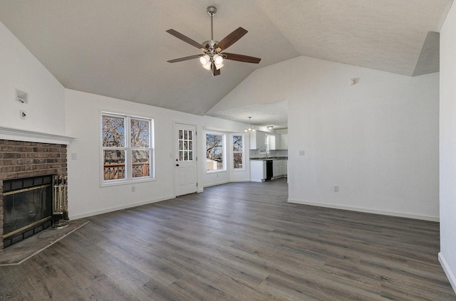 unfurnished living room featuring a fireplace, a ceiling fan, dark wood-style flooring, and lofted ceiling