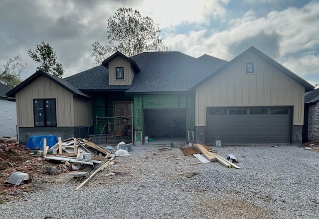 view of front of property with a garage, board and batten siding, driveway, and roof with shingles