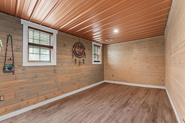 unfurnished room featuring wooden ceiling, a wealth of natural light, and wood finished floors