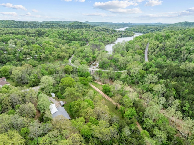 drone / aerial view with a water view and a forest view