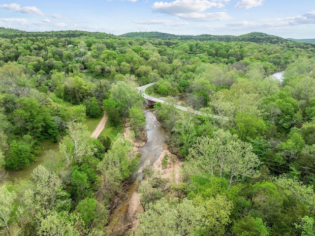 drone / aerial view featuring a wooded view