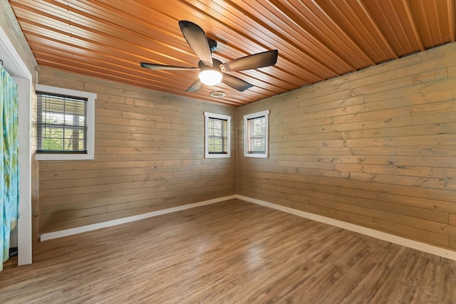 unfurnished room with baseboards, light wood-style floors, ceiling fan, and wooden ceiling