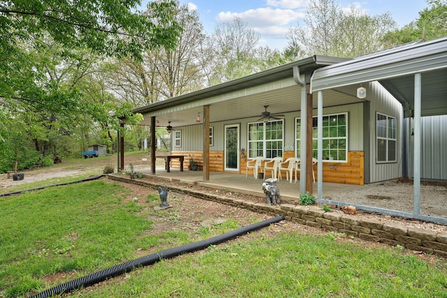 rear view of property with a ceiling fan, a yard, and a porch