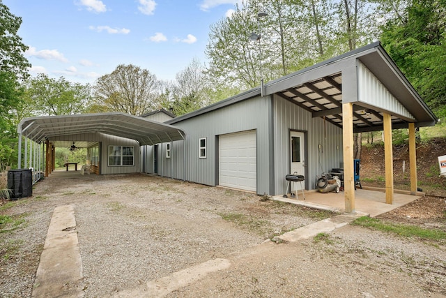 exterior space with a garage, dirt driveway, and a carport