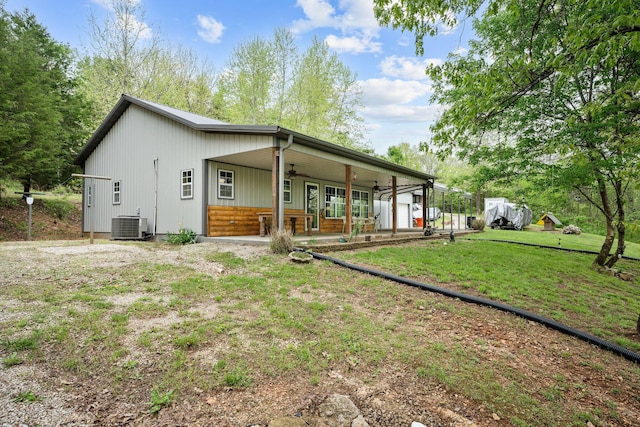 back of house featuring central air condition unit, covered porch, ceiling fan, and a lawn