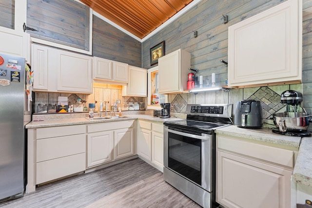 kitchen featuring a sink, stainless steel appliances, wooden ceiling, tasteful backsplash, and vaulted ceiling