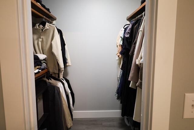 walk in closet with wood finished floors