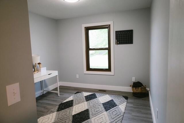 bedroom featuring baseboards, visible vents, and wood finished floors