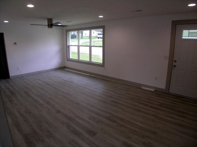 empty room featuring dark wood-style flooring, recessed lighting, and a wealth of natural light