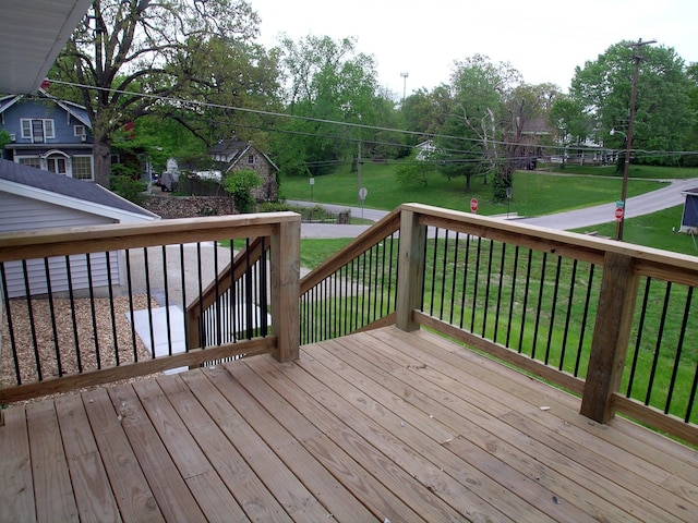 wooden deck featuring a lawn