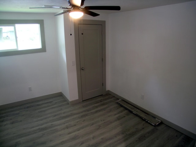 unfurnished room with baseboards, ceiling fan, and wood finished floors