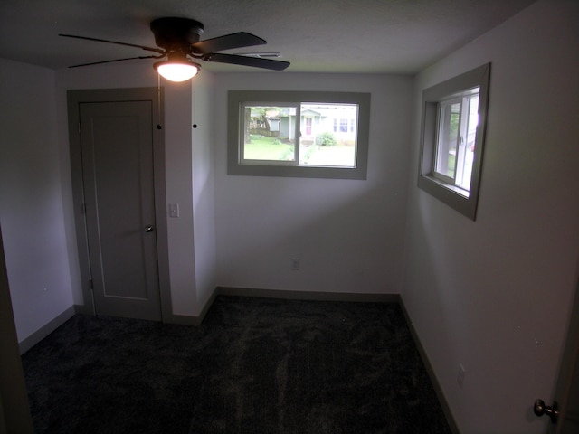 spare room featuring carpet floors, ceiling fan, and baseboards