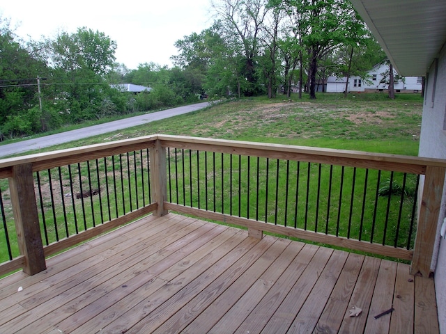 wooden terrace featuring a lawn