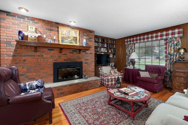 living area with wood finished floors and a brick fireplace