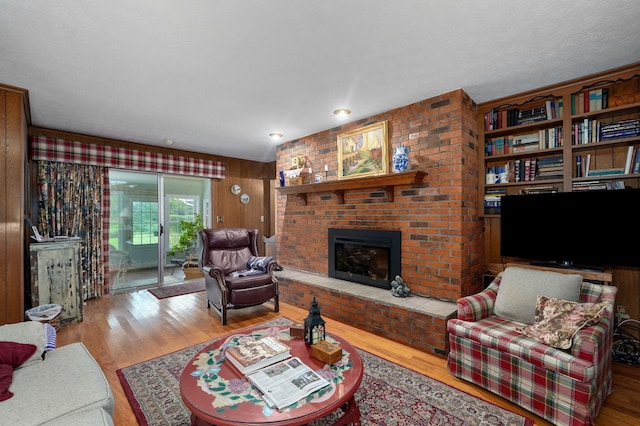 living area featuring a brick fireplace and wood finished floors
