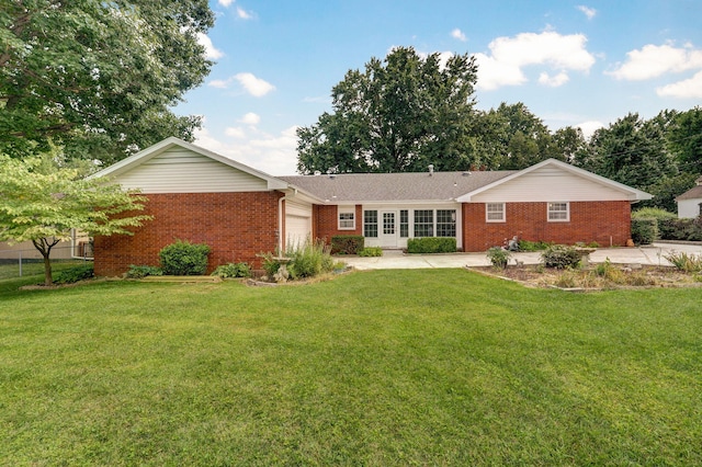 view of front of home featuring brick siding, an attached garage, and a front lawn